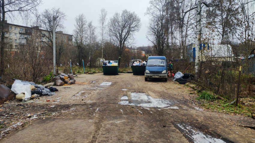 Мусорные контейнеры и автомобиль на коммунальной площадке