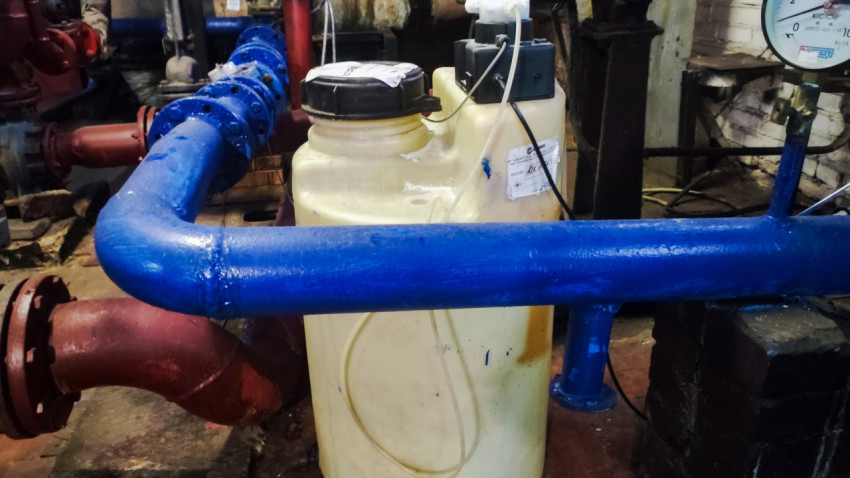 Емкость с дозирующим оборудованием возле трубопровода