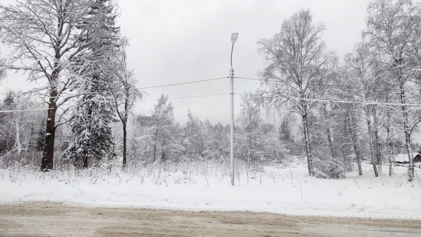 Опора уличного освещения на обочине зимней дороги