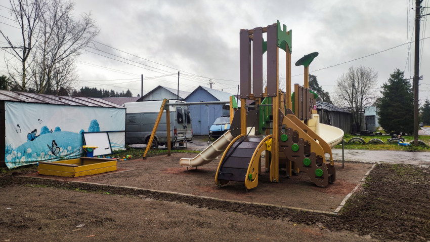 Детская игровая площадка с горкой и песочницей в жилом посёлке