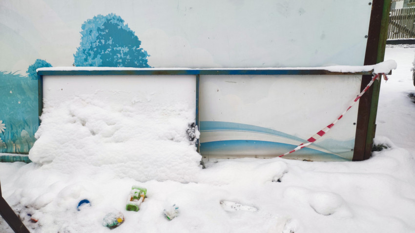 Снежный сугроб у декоративного стенда с детскими игрушками