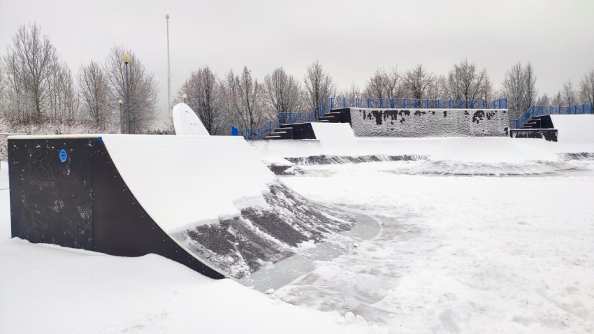 Радиусная рампа скейтпарка с логотипом производителя под снегом