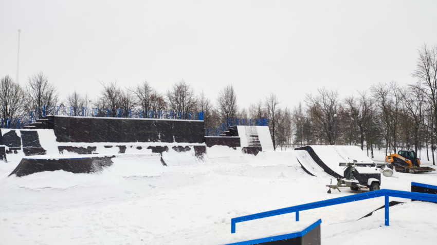 Зимний скейтпарк с техникой и элементами трассы