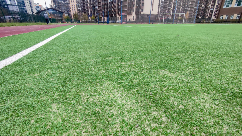 Искусственное покрытие футбольного поля с белой разметкой