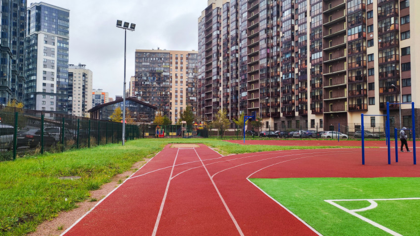 Легкоатлетические дорожки и футбольное поле во дворе жилого комплекса