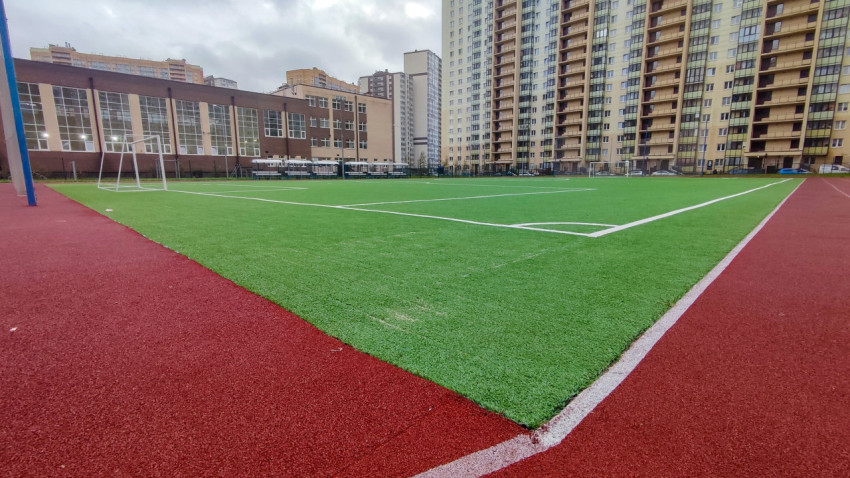 Угол футбольного поля с искусственным покрытием рядом со школой