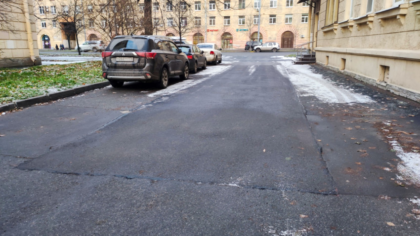 Асфальтированная дворовая дорога между жилыми зданиями зимой