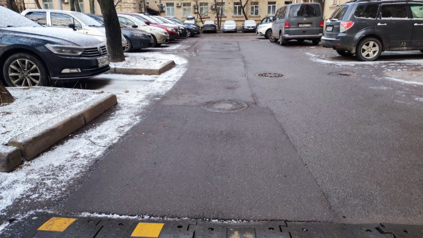 Асфальтированная проезжая часть во дворе жилого дома зимой