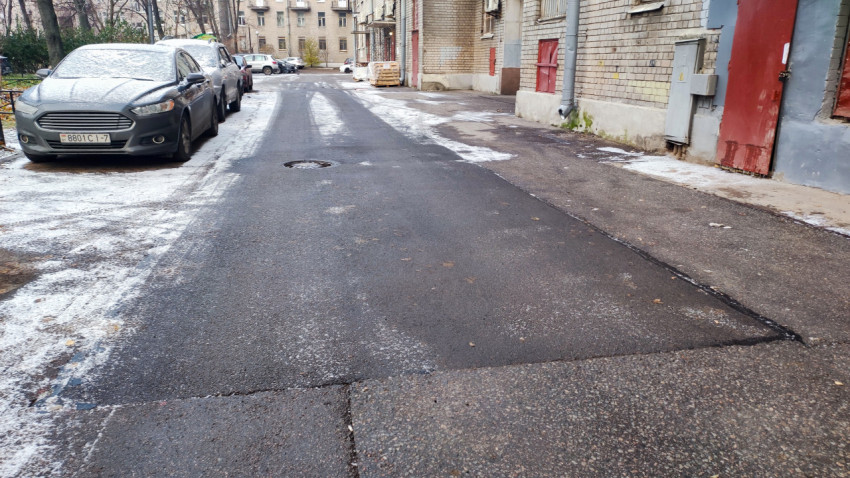 Асфальтовое покрытие у фасада кирпичного дома после ремонта