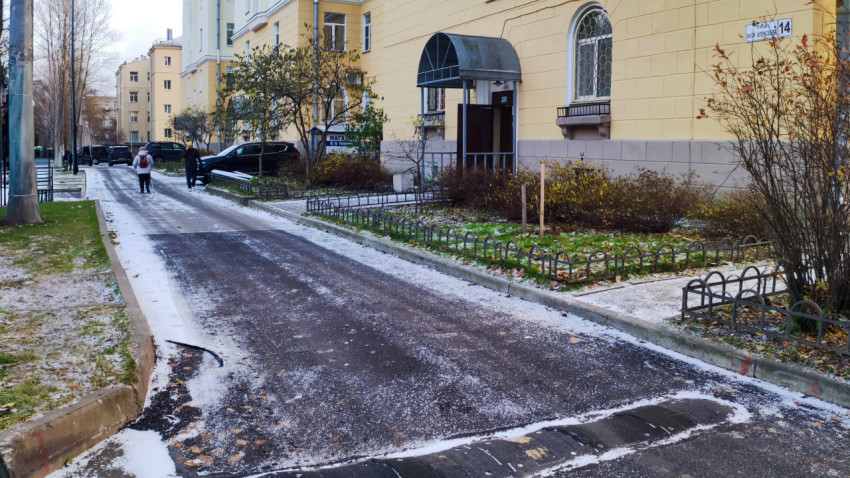 Асфальтированная дворовая дорога у жилого дома с жёлтым фасадом