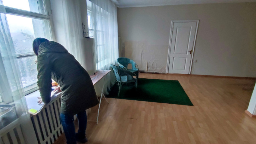 Обследование помещения с большими окнами и мебелью из ротанга