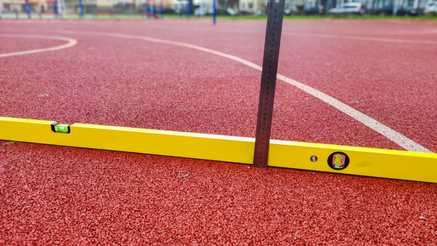 Измерение высоты перепада на спортивном покрытии при помощи уровня и линейки