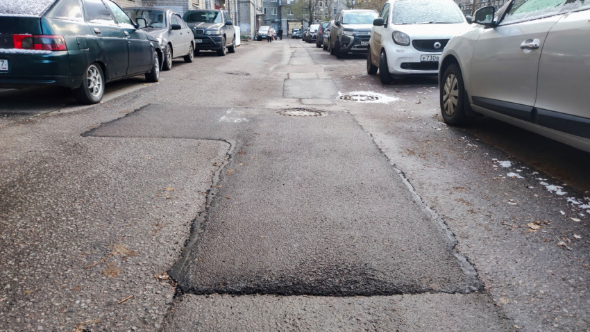 Участок дворовой дороги с заплатками на асфальте