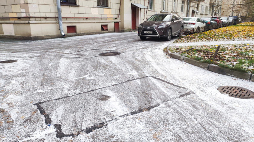 Асфальтированный двор жилого квартала с припаркованными машинами зимой