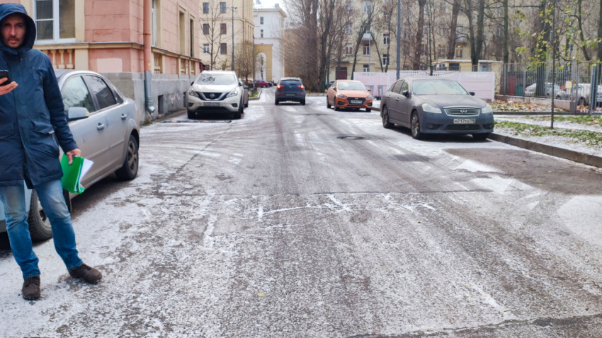 Дворовая дорога с припаркованными автомобилями и человеком при осмотре территории