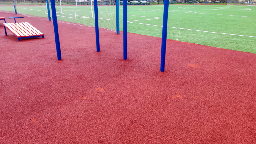 Зона турников и скамеек на спортивной площадке с резиновым покрытием