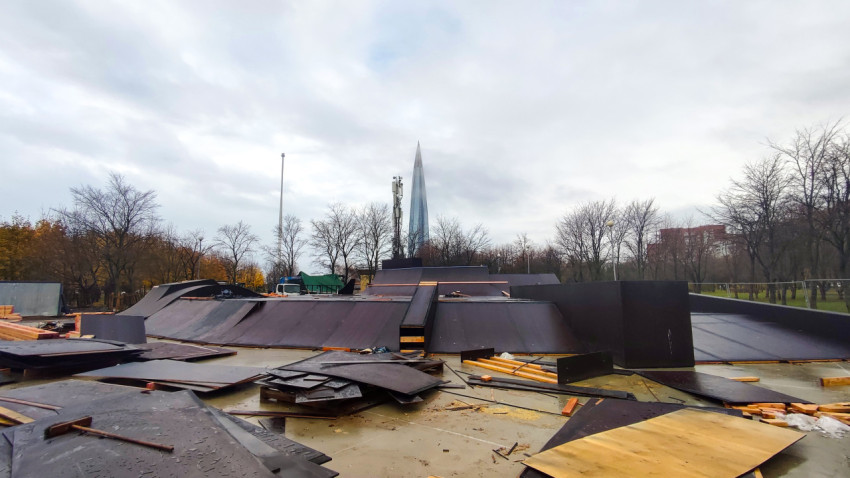 Строительство рампы в скейт-парке на фоне городской застройки