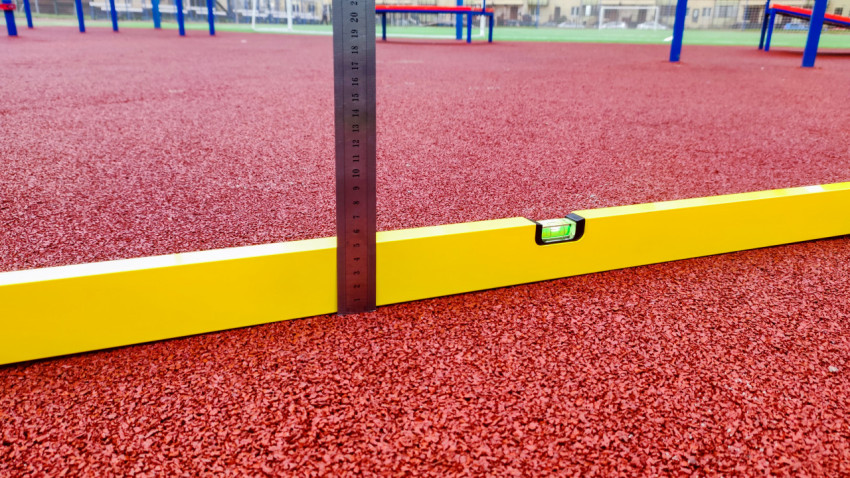 Измерение перепада высот на резиновом покрытии с помощью уровня и линейки