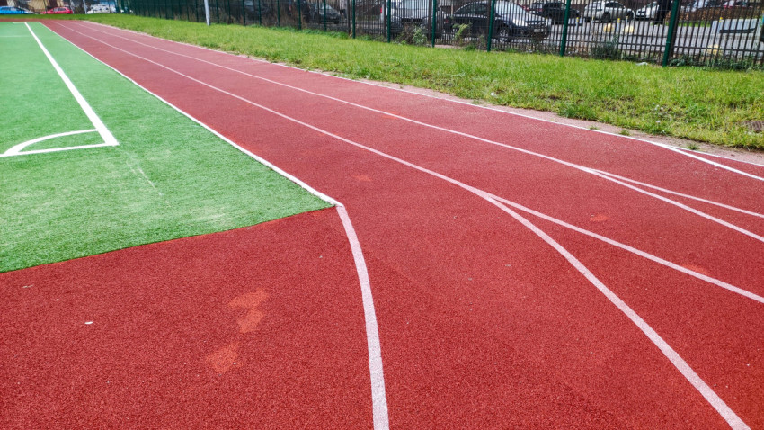 Беговые дорожки с резиновым покрытием возле футбольного поля
