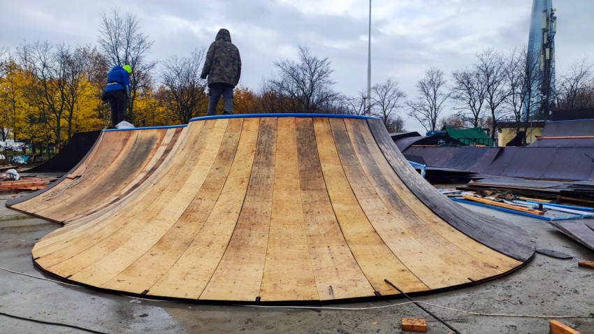 Рабочие на монтаже деревянной рампы для скейт-парка