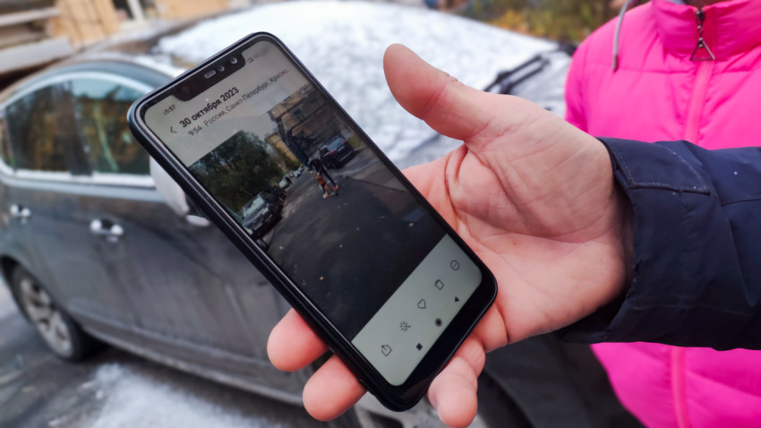 Проверка состояния дворовой дороги по фотографии на экране смартфона