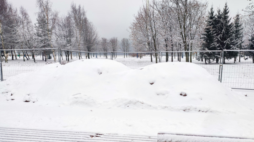 Снеговые кучи на строительной площадке в городском парке