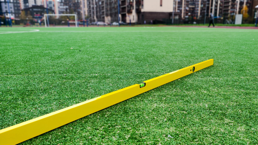 Строительный уровень на футбольном поле с искусственным покрытием