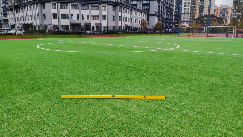 Проверка ровности покрытия футбольного поля строительным уровнем