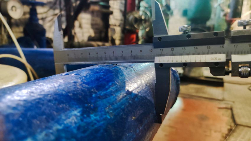 Крупный план измерения наружного диаметра стальной трубы штангенциркулем