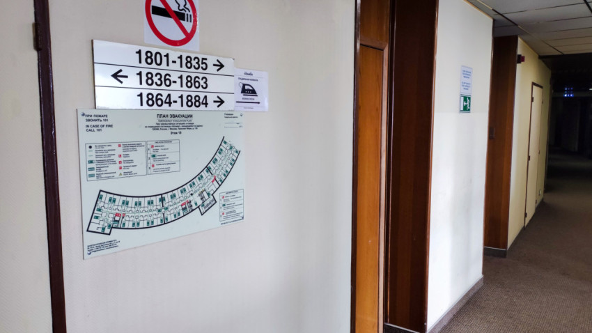 Указатели этажей и план эвакуации в отельном коридоре