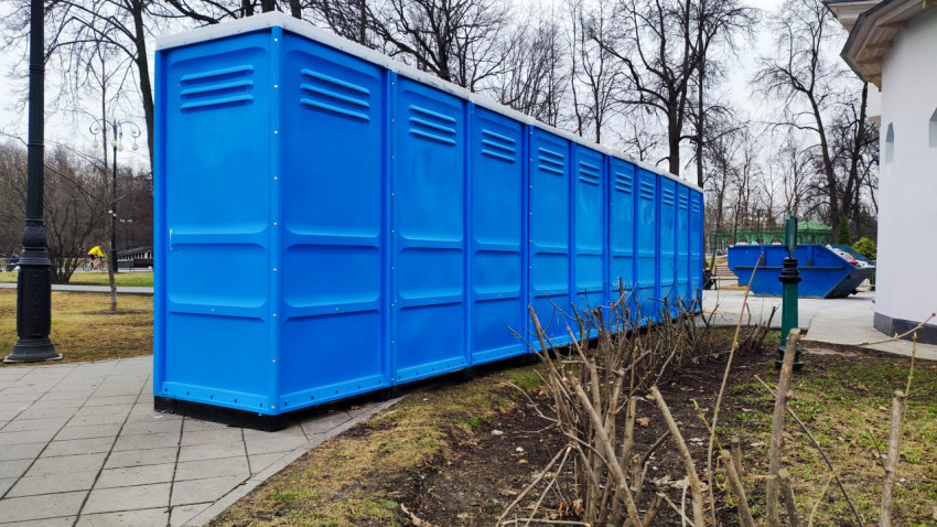 Задняя часть блока мобильных туалетов в парковой зоне