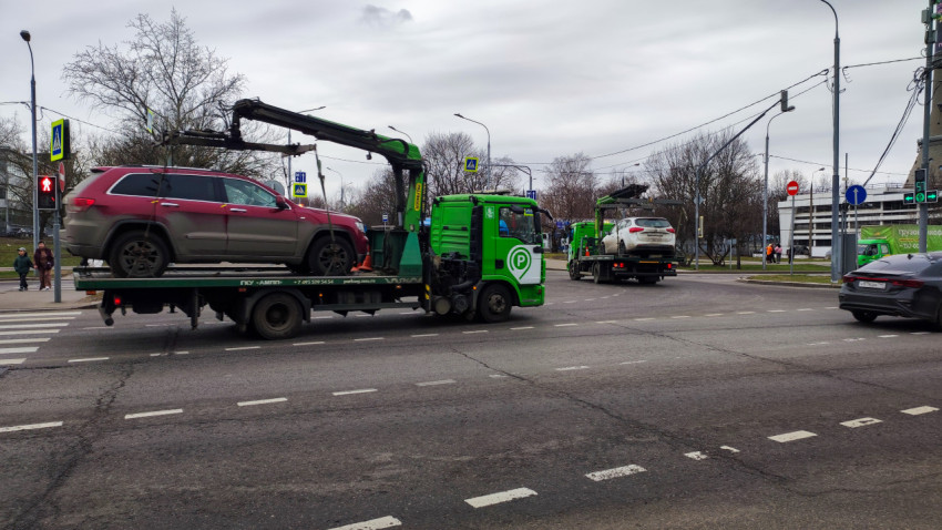 Эвакуаторы перевозят автомобили на городской улице
