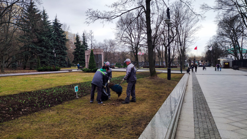 Работники парка, убирающие территорию весной