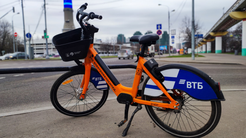 Электровелосипед городского проката на фоне транспортной магистрали