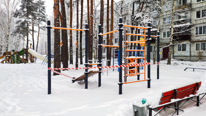 Спортивная площадка во дворе многоэтажного дома зимой
