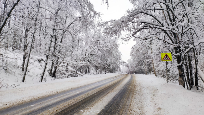Зимняя дорога с предупреждающим знаком пешеходного перехода