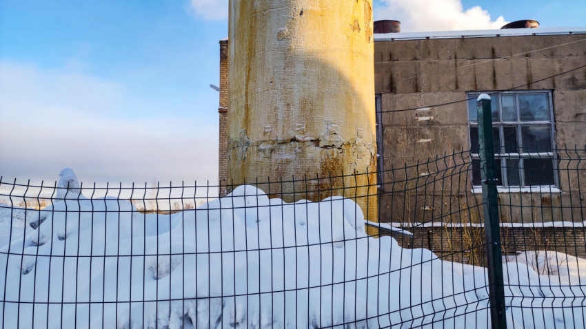 Нижняя часть бетонной трубы у стены производственного корпуса