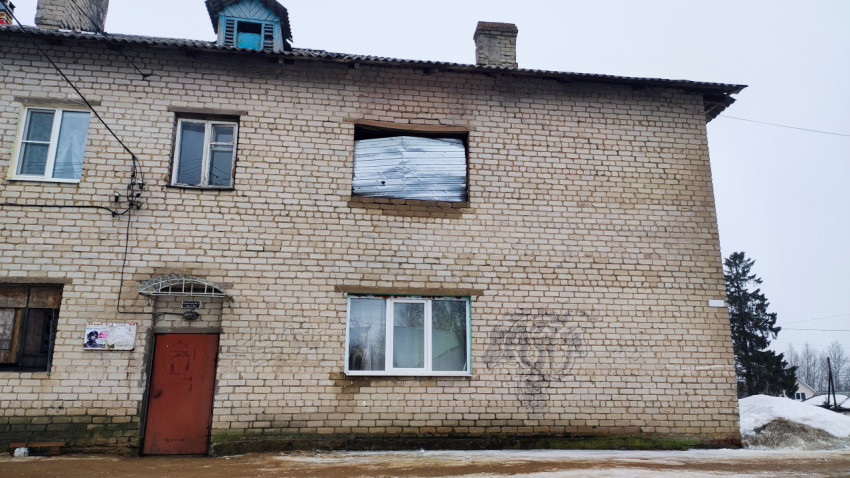 Кирпичный фасад с закрытым оконным проёмом на втором этаже