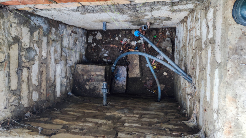 Инженерный колодец с трубопроводами и грязевой отложенностью