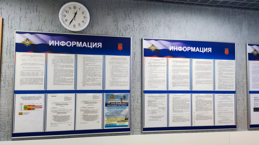Информационные стенды МВД с настенными часами в помещении приема граждан