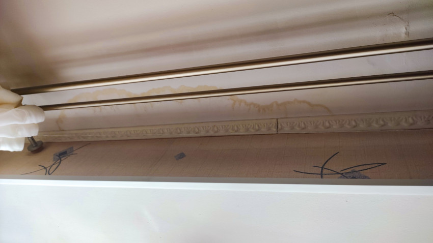 Подтеки влаги на стене под потолком у карниза