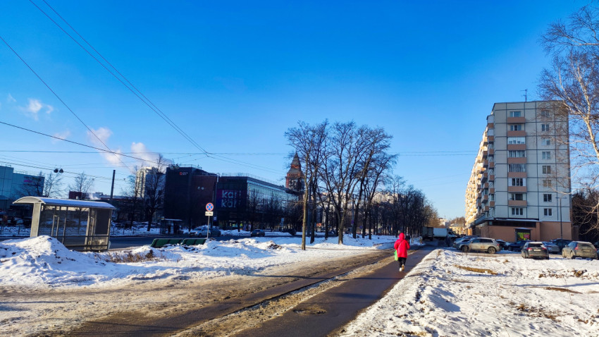 Зимняя улица с жилыми домами и пешеходом