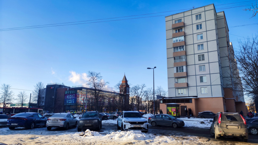 Парковка у жилого дома и торгового центра зимой