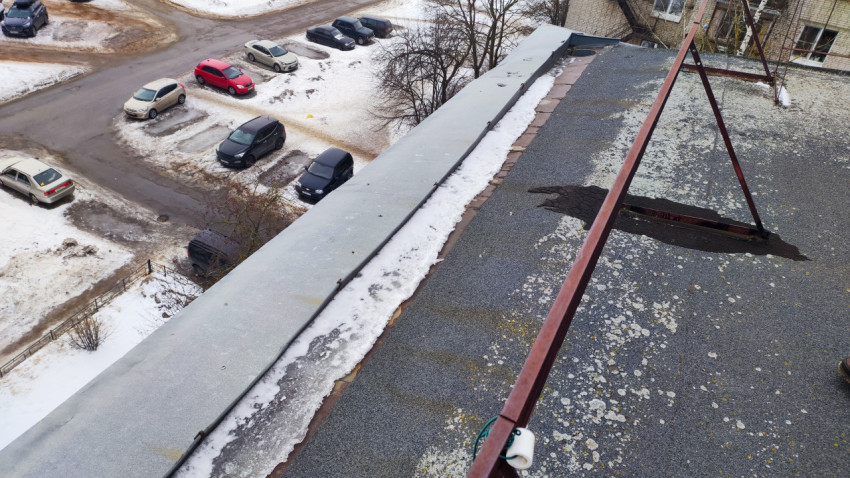 Плоская кровля с металлическим козырьком и снежным остатком