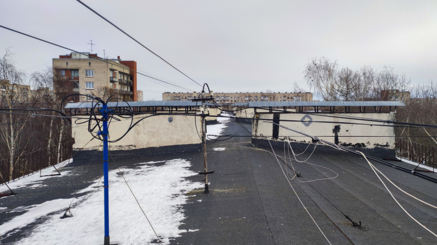 Телекоммуникационные кабели и опоры на крыше дома