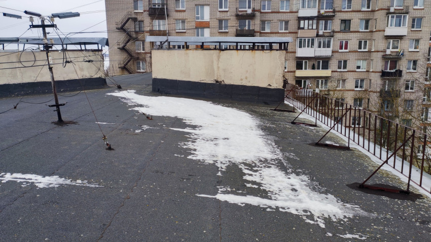 Снег на плоской кровле многоэтажного жилого дома