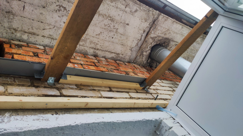 Деревянные стропила и вентиляционный канал на фасаде балкона