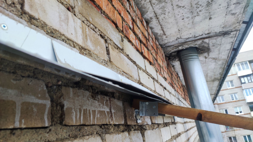 Примыкание кровельного профиля и кирпичной стены балкона