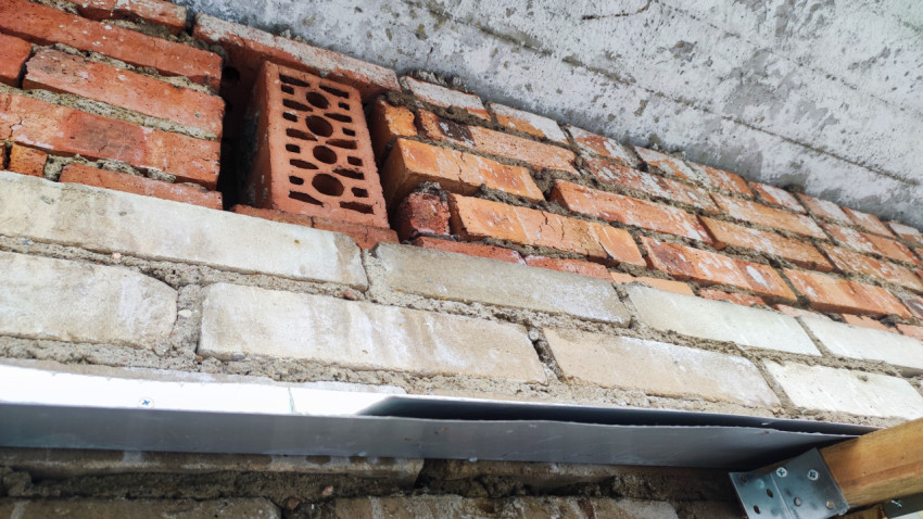 Кирпичная кладка под бетонным козырьком