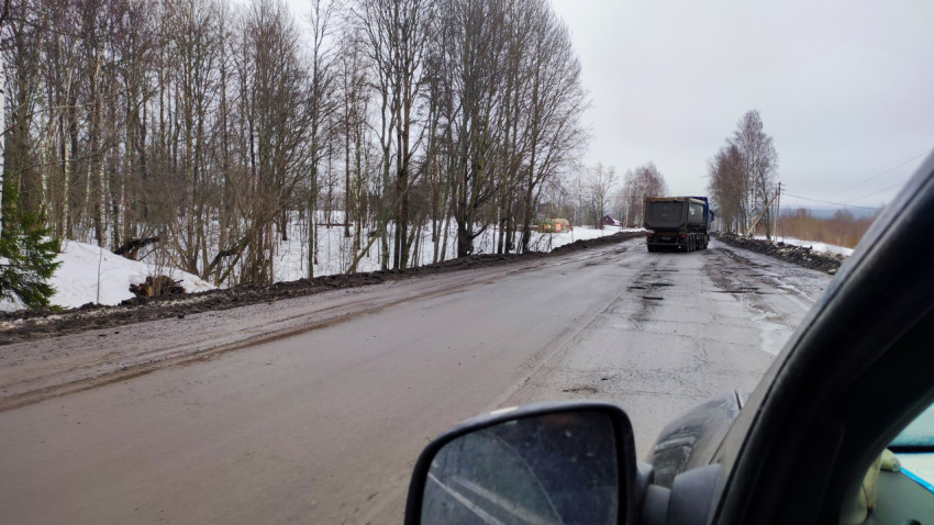 Обочина ремонтируемой дороги с проезжающим грузовым транспортом